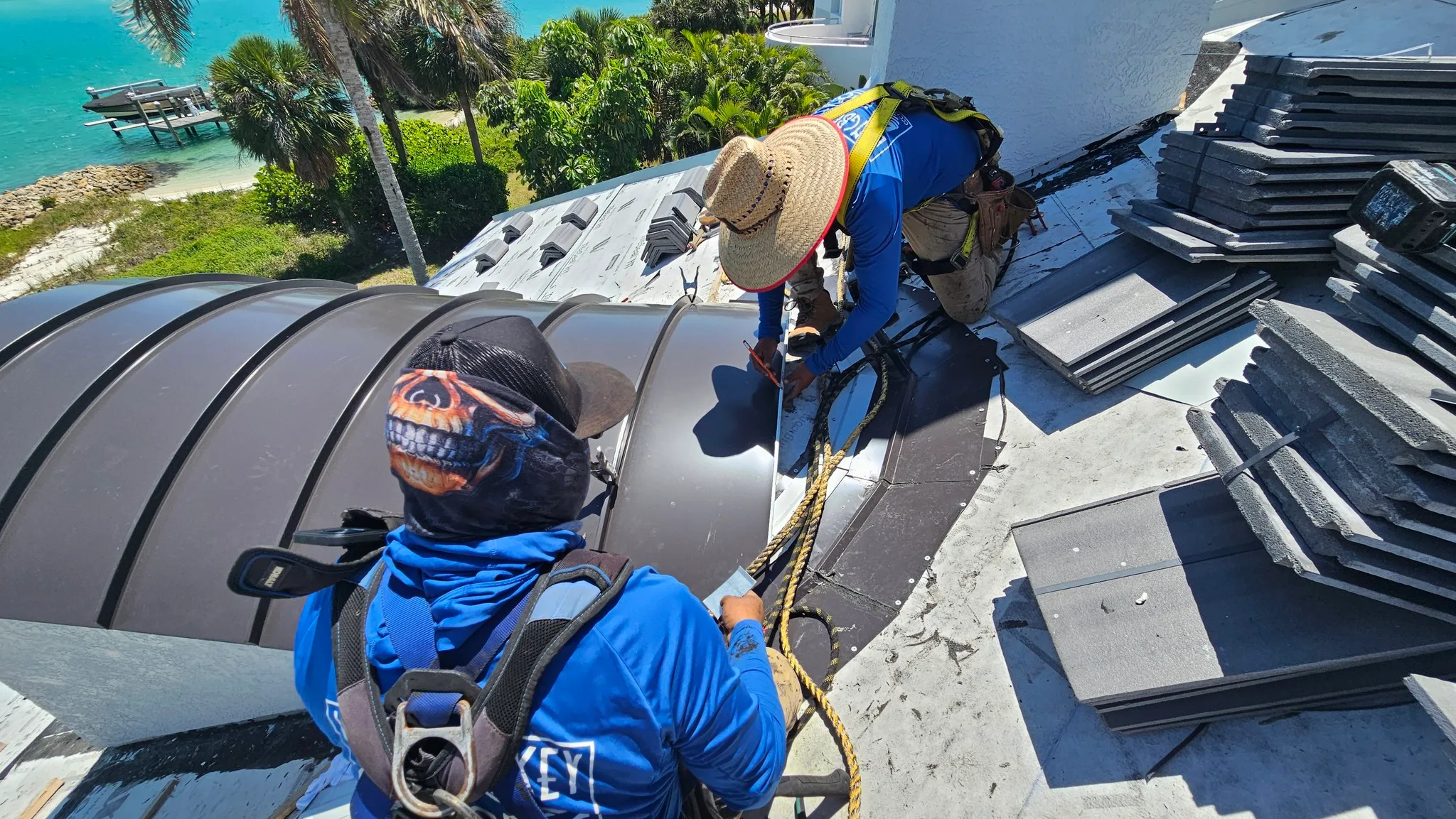 Roof contractors working on tile and metal roof