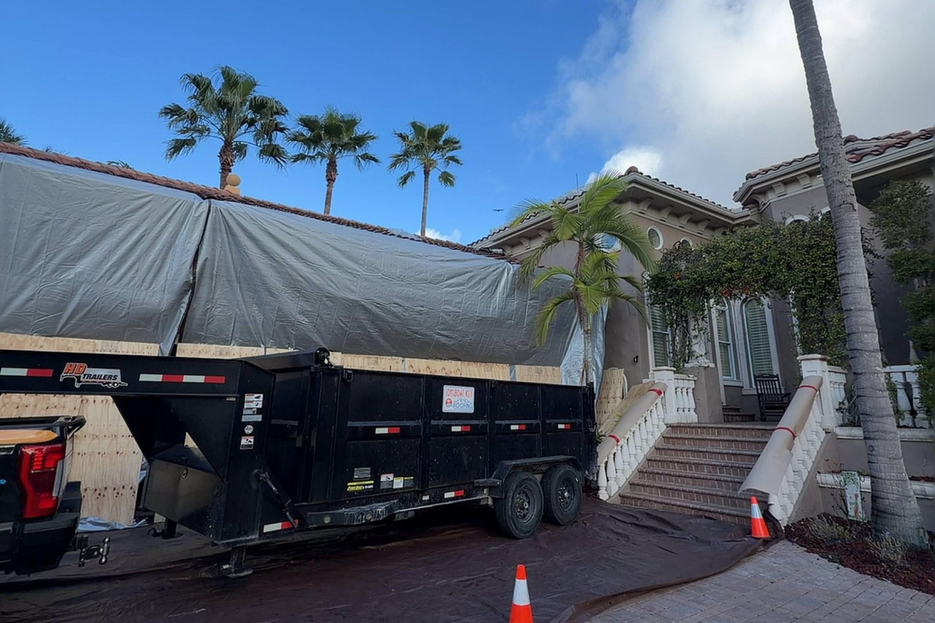 Longboat Key Roofing crew setting up driveway protection during roof replacement planning